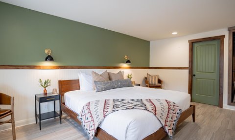Ein stilvolles Zimmer mit einem großen, einladenden Bett, dekoriert mit einer roten und weißen Decke.