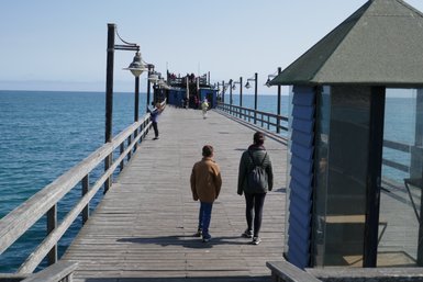 Zwei Personen laufen auf einem Bootssteg - Namibia mit Jugendlichen