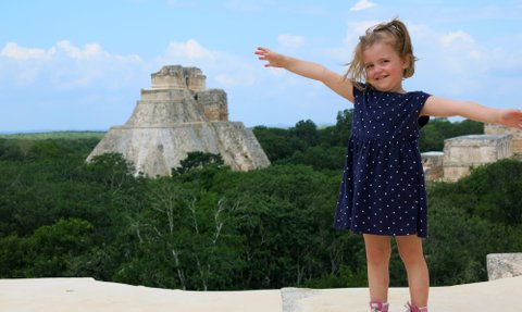 Kleines Mädchen lächelnd vor der Pyramide in Uxmal – Mexiko Familienreise