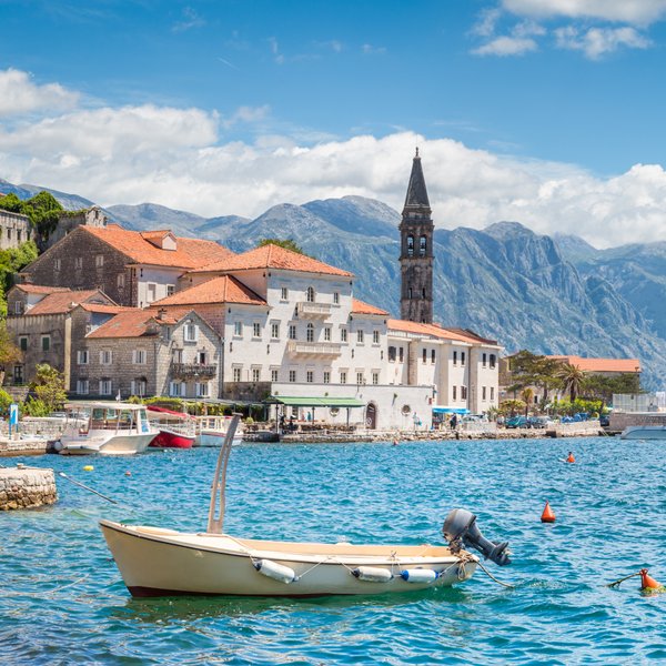 Die Hafenpromenade von Perast bei blauem Himmel