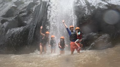 Familie unter einem Wasserfall – Indonesien Reise mit Kindern
