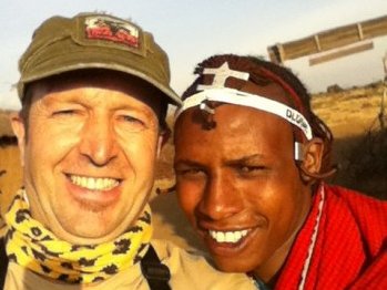 Reisender begegnet Massai-Mann im Dorf – Tansania Familienreise