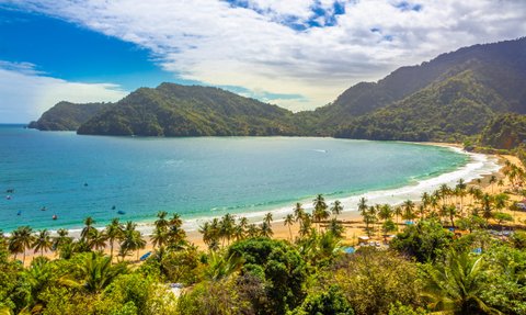 Ein atemberaubender Blick auf die Küste von Maracas Bay, umgeben von üppigen Bergen und klarem, blauem Wasser.