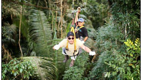 Teen fröhlich beim Ziplining durch den tropischen Wald – Mexiko Familienreise