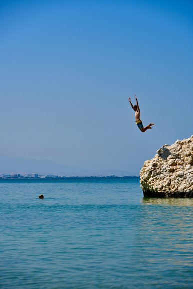 Kind springt ins Wasser am Strand vom Crowne Plaza Muscat – Oman Reise mit Kindern