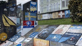 Bunte Wandmalereien und Graffiti zieren die Treppenstufen, während ein elegantes Gebäude im Hintergrund sichtbar ist.