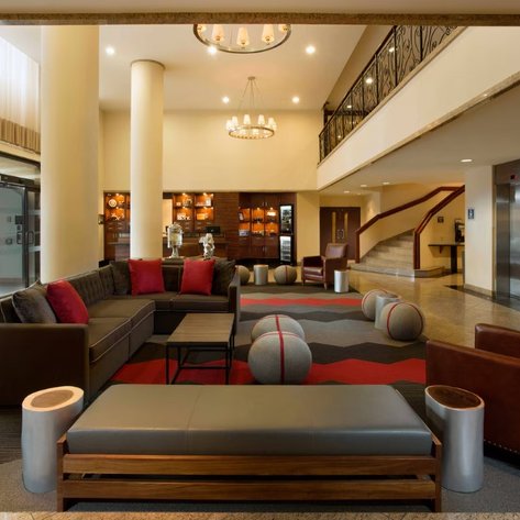Der Empfangsbereich des Four Points Hotels zeigt eine moderne Einrichtung mit bequemen Sofas und stilvollen Stühlen.
