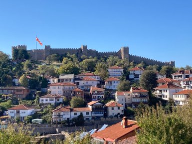 Die alte Stadt Ohrid mit ihren charmanten Häusern und der beeindruckenden Festung im Hintergrund unter strahlend blauem Himmel.