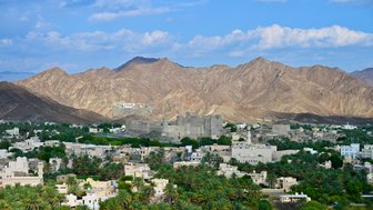 Aussicht auf Palmen und Häuser vom Bahla Fort im Oman – Oman mit Kindern