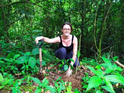 Frau lächelt beim Baumpflanzen in La Tigra – Costa Rica Reise mit Kindern