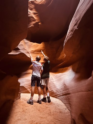 Zwei Kinder stehen in einer engen Schlucht und zeigen begeistert auf die beeindruckenden Felsformationen über ihnen.
