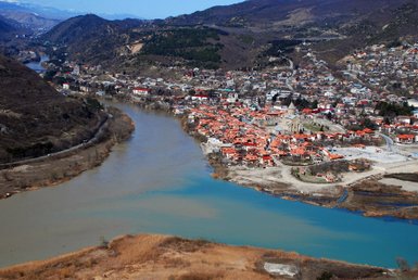Eine malerische Aussicht auf die Stadt Mtskheta, umgeben von Bergen und dem Zusammenfluss zweier Flüsse.