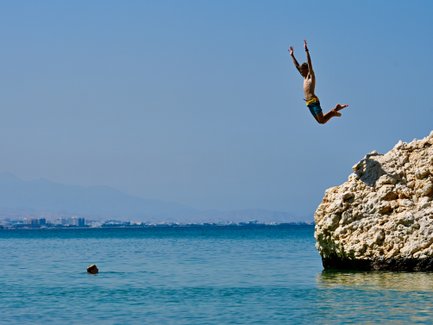 Kind springt ins Wasser am Strand vom Crowne Plaza Muscat – Oman Reise mit Kindern