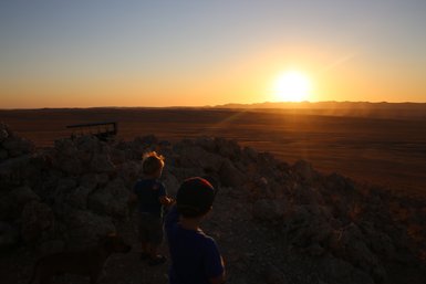 Zwei Kinder schauen neugierig in die weite Wüstenlandschaft - Namibia Urlaub mit Kindern