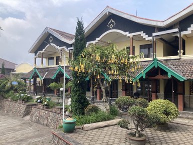 Ein malerisches Lodge-Gebäude mit bunten Dächern und üppiger Vegetation umgibt den einladenden Innenhof.