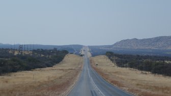 Panoramablick auf eine weite Straße - Namibia mit Jugendlichen