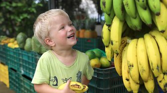 Kleines Kind greift nach Bananen – Costa Rica Familienreise