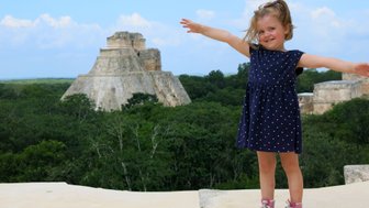 Kleines Mädchen lächelnd vor der Pyramide in Uxmal – Mexiko Familienreise