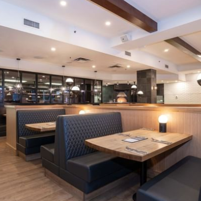 Ein modernes Restaurant mit eleganten, gepolsterten Sitzbänken und warmem Holzdekor, das eine einladende Atmosphäre schafft.