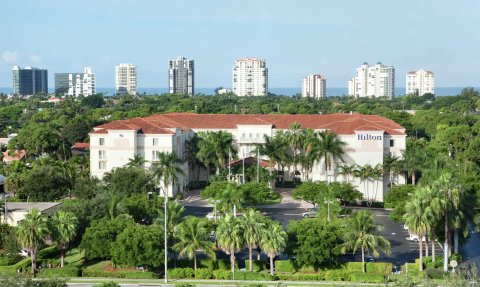 Ein luxuriöses Hilton-Hotel umgeben von üppigen tropischen Pflanzen und majestätischen Palmen, ideal für Entspannung.