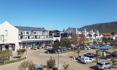 Eine weitläufige Ansicht des Whale Coast Hotels mit modernen Gebäuden und einem klaren blauen Himmel im Hintergrund.