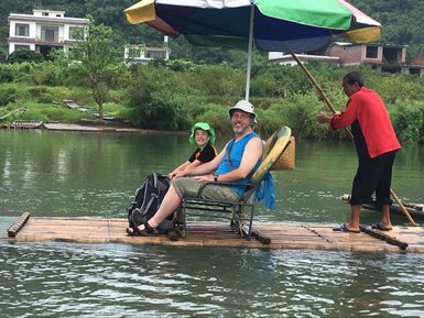 Vater und Kind genießen die Bambusfloßfahrt auf dem Yulong-Fluss – China mit Kindern