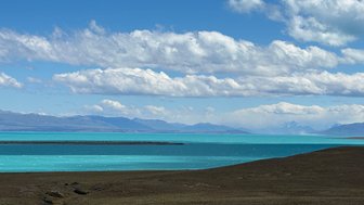 Ein atemberaubender Blick auf den Lago Argentino, dessen türkisfarbenes Wasser sich unter einem strahlend blauen Himmel erstreckt.