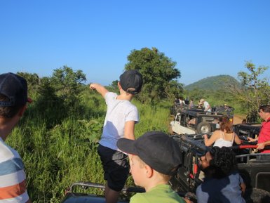 Auf Safari im Minneriya Nationalpark zeigt ein Kind begeistert auf Landschaft – Sri Lanka Reise mit Kindern