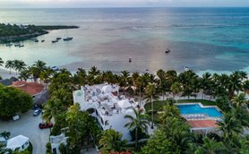 Ein atemberaubender Blick auf das ruhige Wasser mit Booten und einer palmengesäumten Küste in einem tropischen Paradies.