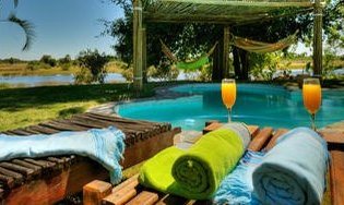 Ein einladender Poolbereich mit bunten Handtüchern und erfrischenden Cocktails, umgeben von üppiger Natur.