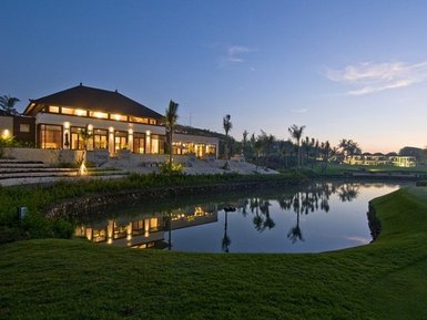 Ein Golfresort in der Abendstimmung, mit einem eleganten Gebäude und einem Teich, der die Umgebung perfekt reflektiert.