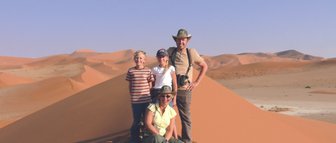 Eine Familie steht auf einer Sanddüne - Namibia mit Kindern