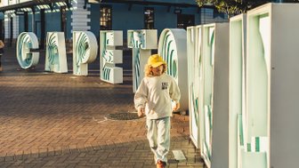 Kind steht vor dem „Cape Town“-Schild – Südafrika Familienreise