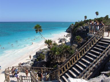 Holzstufen führen hinab zum kristallklaren Strand von Tulum – Mexiko Reise mit Kindern