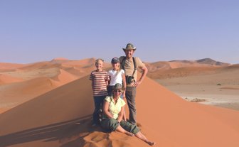 Eine Familie steht auf einer Sanddüne - Namibia mit Kindern