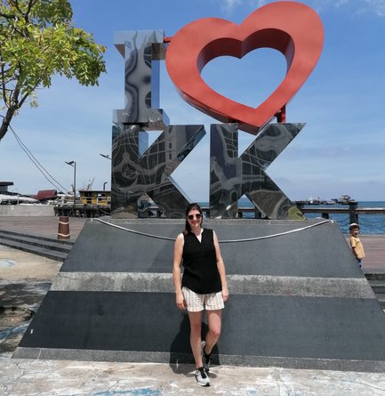 Frau steht vor dem berühmten Kota Kinabalu Schriftzug und genießt den Ausblick auf die Küste – Malaysia & Borneo mit Kindern