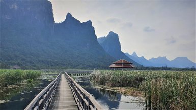 Blick von einem Steg auf eine mächtige Felswand im Khao Sam Roi Yot National Park - Thailand mit Kindern