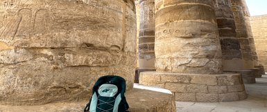For Family Reisen-Rucksack lehnt an einer antiken Säule im Karnak-Tempel – Ägypten Reise mit Kindern