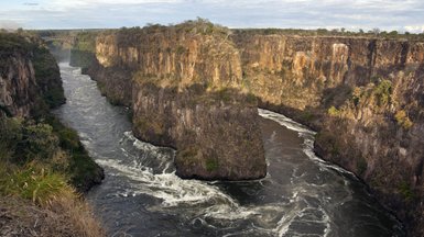 Ein beeindruckender Blick auf die Schluchten des Zambezi-Flusses, umgeben von steilen, bewaldeten Klippen.