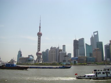 Fähren passieren die Skyline von Pudong auf dem Huangpu-Fluss – China mit Kindern
