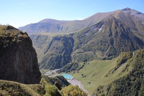 Eine beeindruckende Berglandschaft mit sanften Hügeln und einem klaren blauen See in der Mitte des Tals.