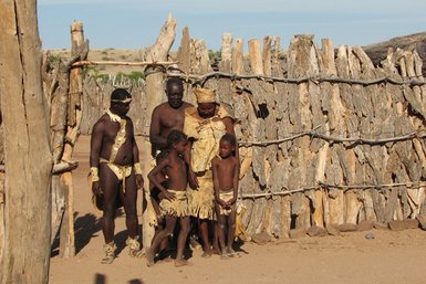 Eine Familie mit zwei Kindern steht vor einem Tor - Namibia mit Jugendlichen