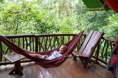 Kind liegt gemütlich in Hängematte im Baumhaus in La Tigra – Costa Rica Reise mit Kindern