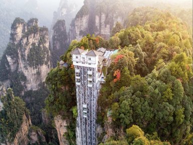 Ein beeindruckender Blick auf den Bailong-Aufzug, der an einer steilen Klippe inmitten üppiger grüner Wälder thront.