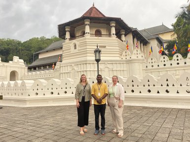 Reiseleiter und Frauen posieren gemeinsam vor dem Zahntempel in Kandy – Sri Lanka Familienreise