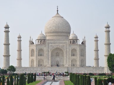 Das majestätische Taj Mahal erhebt sich mit seinen hohen Minaretten und der beeindruckenden Kuppel vor einem klaren Himmel.