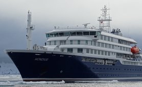Das Schiff 'Hondius' liegt majestätisch im Wasser, umgeben von Eis und einer dramatischen, bewölkten Landschaft.