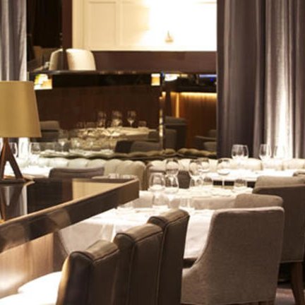 Elegante Restaurantatmosphäre mit stilvollen Möbeln, sanfter Beleuchtung und einem einladenden Tischarrangement.