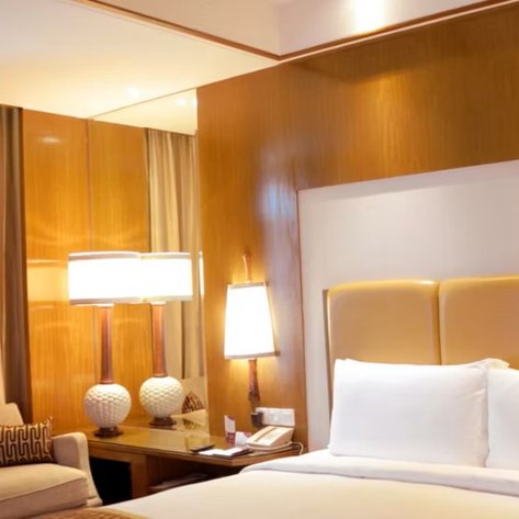 Ein elegantes Hotelzimmer mit einem großen Bett, sanften Farben und stilvollen Möbeln, das eine entspannende Atmosphäre schafft.