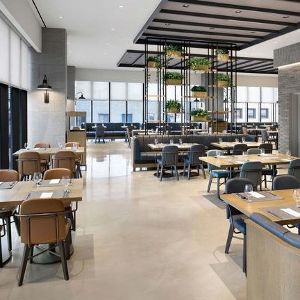 Ein modernes Restaurant mit eleganten Holztischen und Stühlen, umgeben von großen Fenstern, die viel Tageslicht hereinlassen.